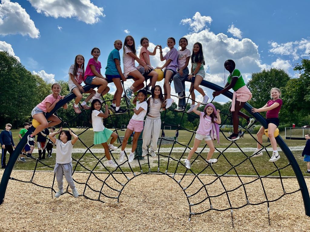 FSS fifth grade students pose together smiling on the playground.