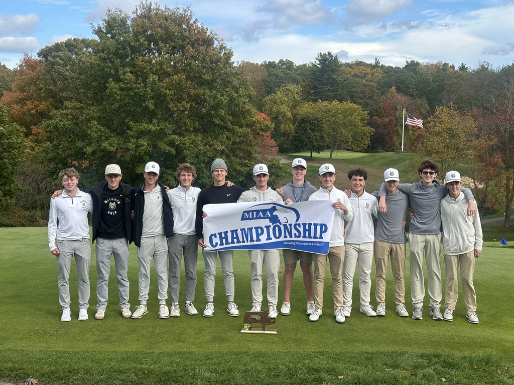 The NRHS Golf Team stands on the green holding a blue and white banner that says MIAA Championship.