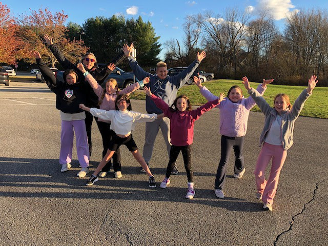 MRE students jump in the air to pose for a picture during their Girls on the Run practice.