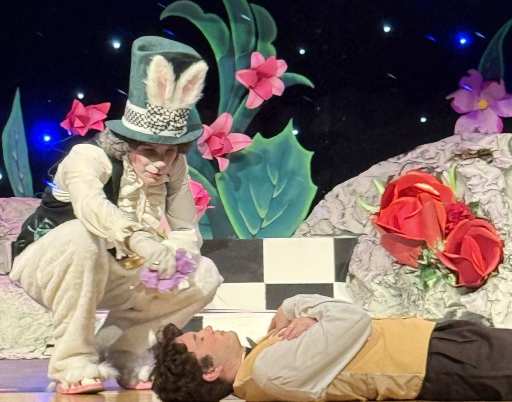 An NRHS students lays on the ground while another dressed as a rabbit leans over him during the dress rehearsal for A Midsummer Night's Dream.
