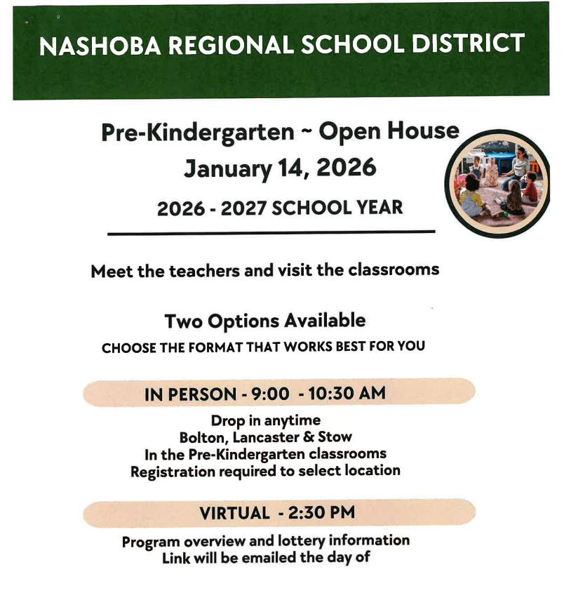 Students sitting on a rug listening to their teacher.