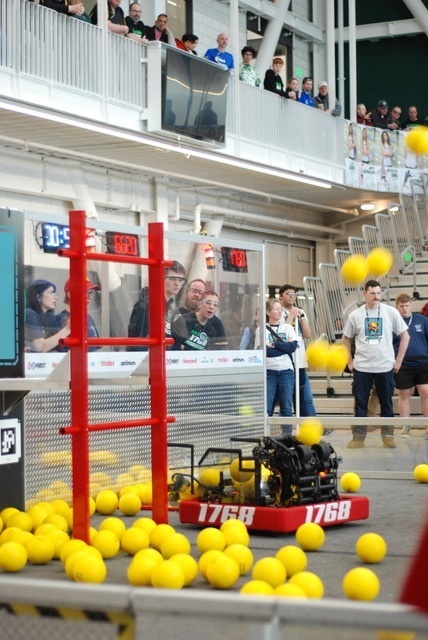 A robot collecting yellow balls in a robotics arena. 
