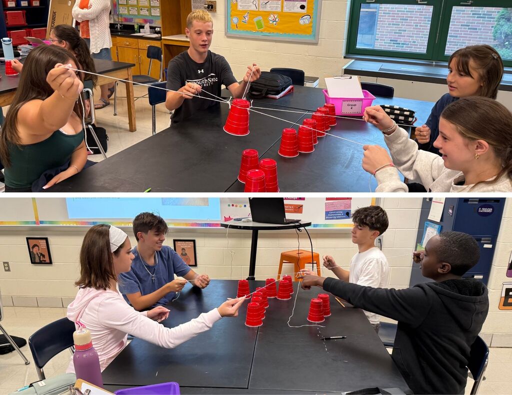 LBMS students work to stack a group of red cups using a piece of string.