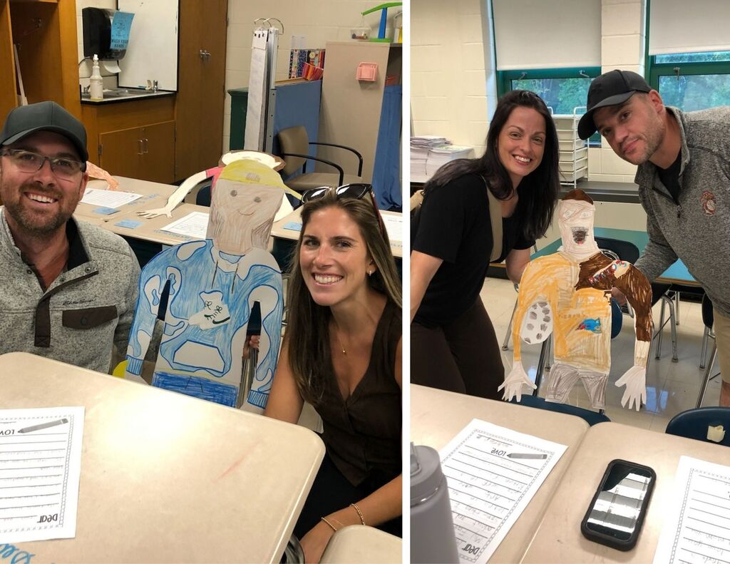 Parents/caregiver pose with paper versions of their student.