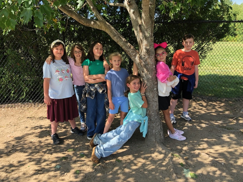 MRE students smile together under a tree at recess.