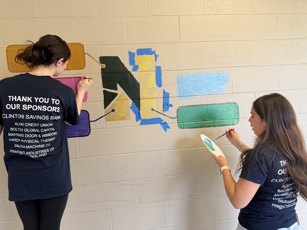 Two NRHS students paint a Nashoba N on the wall.