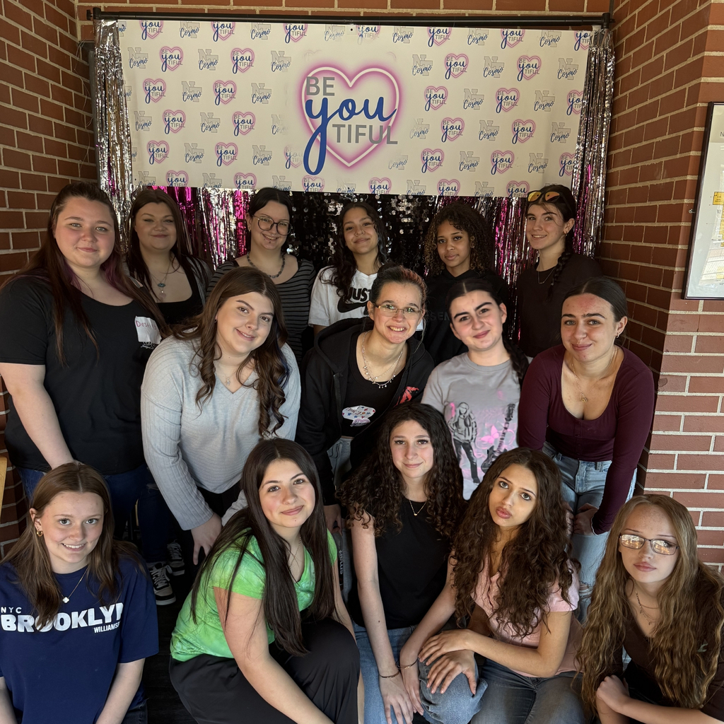 15 Cosmetology students in front of a backdrop t hat reads  be-you-tiful.