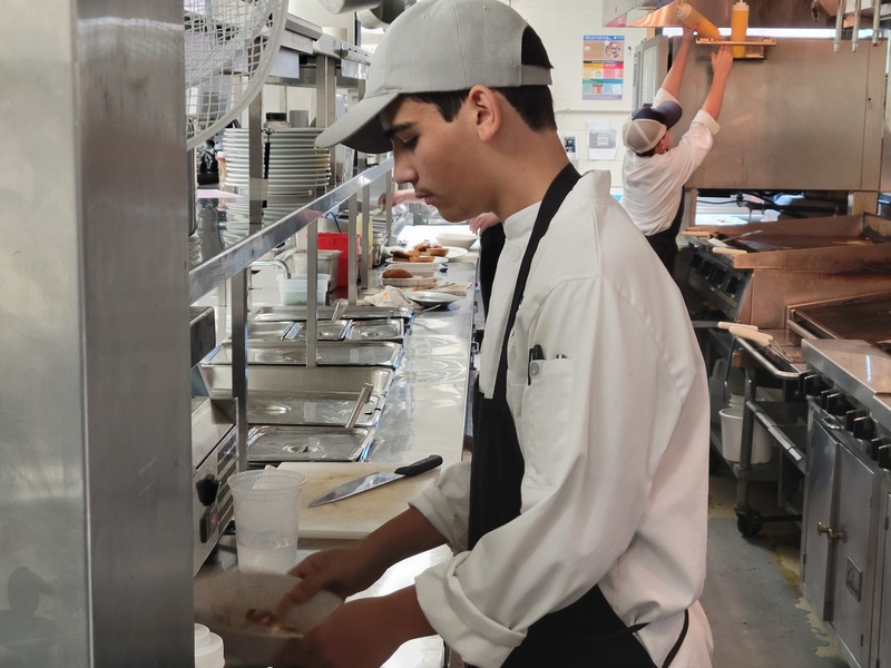 Nikolaos Gkogkos (sophomore, Chelmsford) prepares lunch in the kitchen at the Viking Bistro at Nashoba Tech.