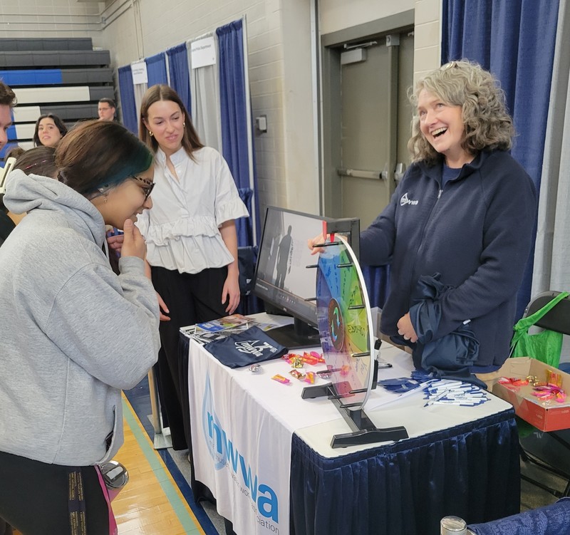 Nayeli Nunez (sophomore, Ayer) takes a spin on the Massachusetts Water Works Association wheel while MWWA’s Hanna Schenkel, center, and Elizabeth Sawyer look on during a recent Career Fair at Nashoba Tech. (COURTESY NASHOBA TECH)