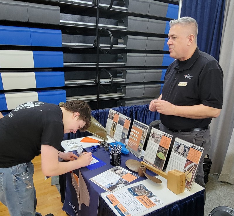 Tyler Nolan (junior, Westford) stops at the The Landing School of Arundel, Maine, to chat with Steve Parello, director of admissions, during a recent career fair at Nashoba Tech. (COURTESY NASHOBA TECH)
