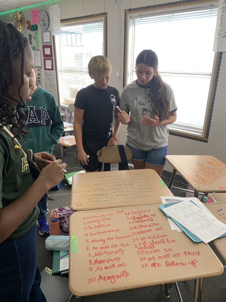 Students learning bywriting in dry erase markers on the desk