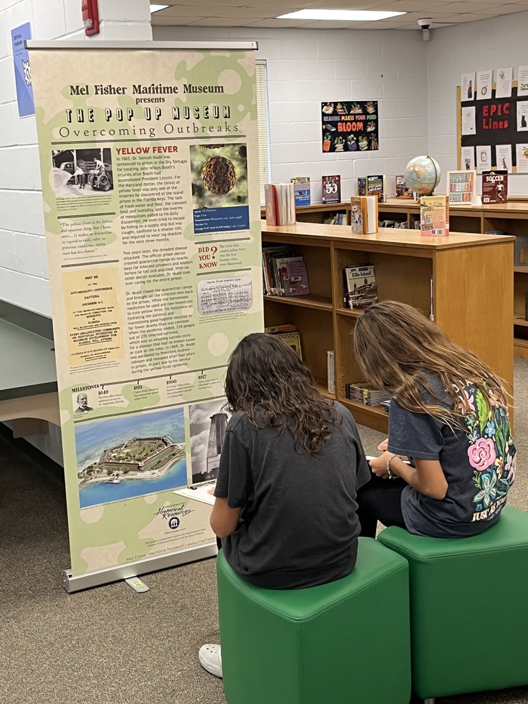 Students studying an exhibit in our pop up museum in the library