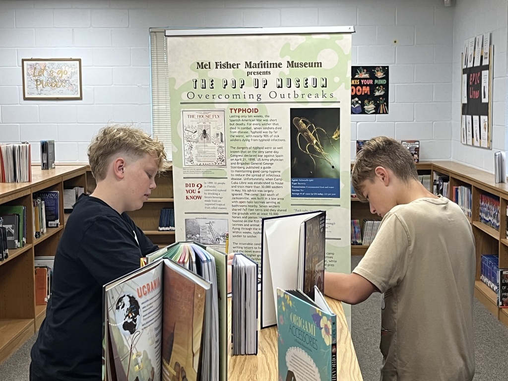 Students studying an exhibit in our pop up museum in the library