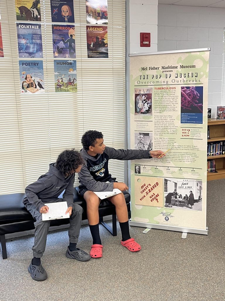 Students studying an exhibit in our pop up museum in the library
