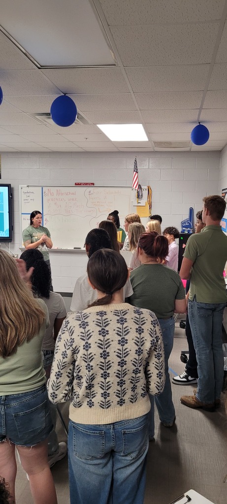 The Yulee High School agriculture teacher speaks to visiting Yulee Middle School students inside the classroom about FFA opportunities, with posters and student notes visible on the whiteboard.
