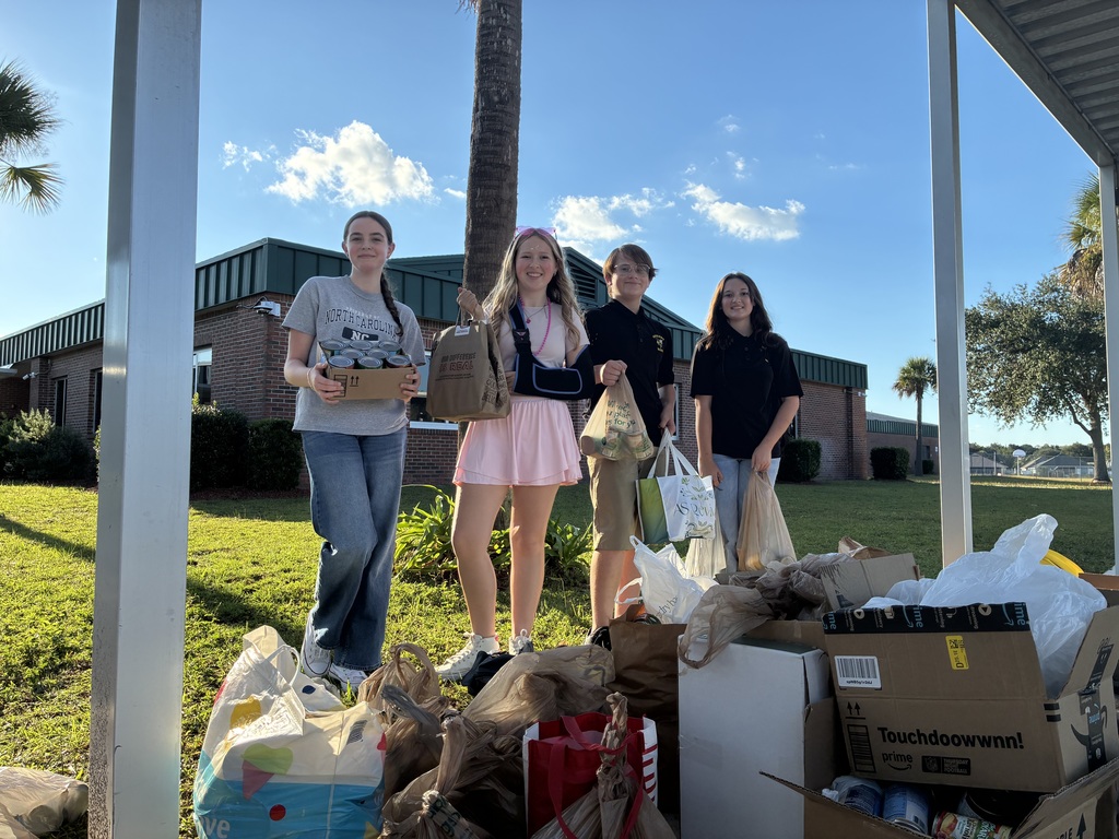 Students posing with canned goods they collected