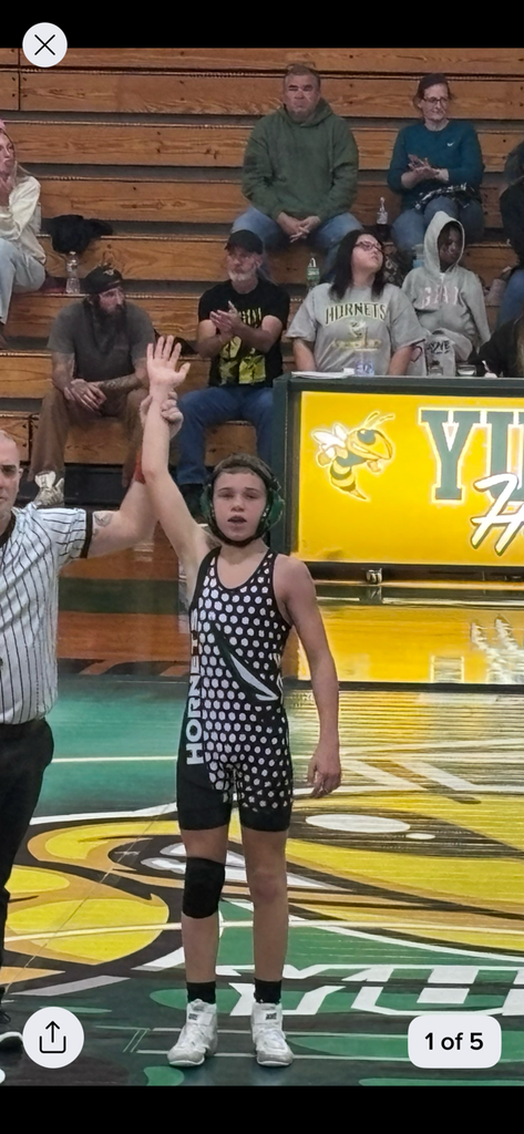 Student having hand raised after winning