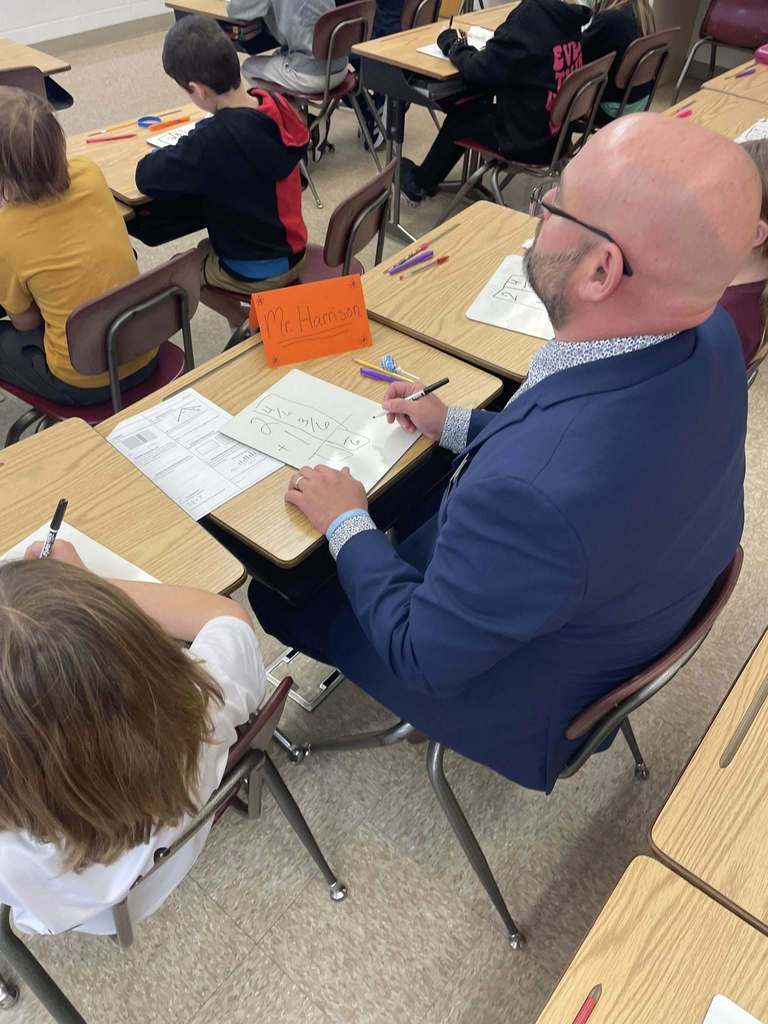 Florida’s Teacher of the Year sits at a student desk working through a math problem alongside students during a classroom lesson at Callahan Intermediate School.