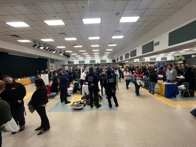 Students and vendors continue conversations throughout the cafeteria during the Nassau County School District College & Career Fair.
