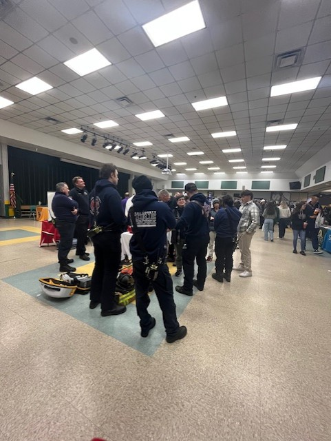 Public safety professionals speak with students near emergency response equipment displayed at the College & Career Fair.