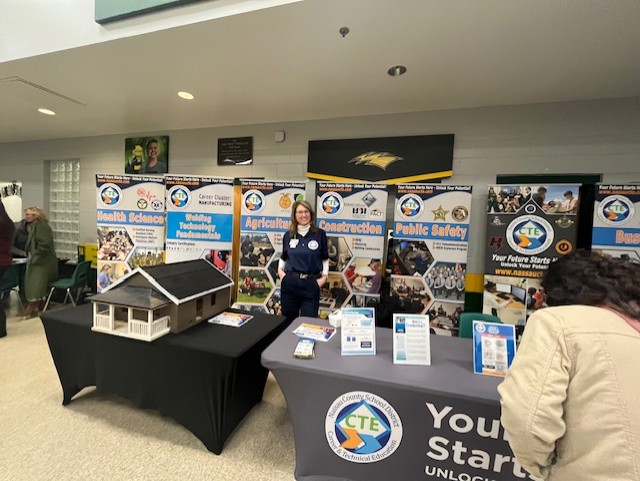 A Nassau County School District Career and Technical Education representative stands behind a CTE display highlighting multiple career pathways.
