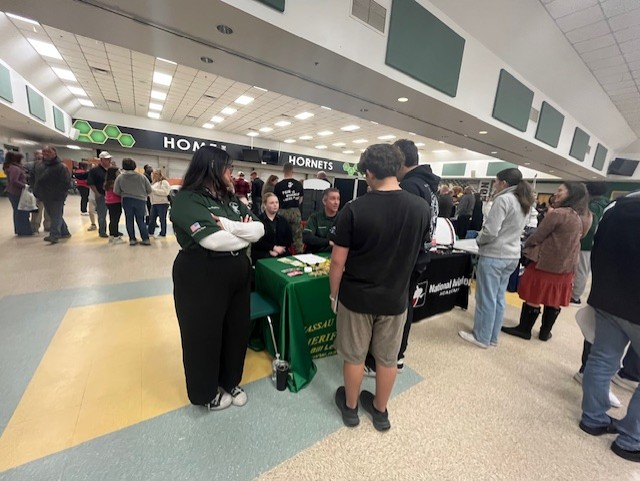 Students gather around a vendor table inside the Yulee High School cafeteria during the Nassau County School District 2026 College & Career Fair.