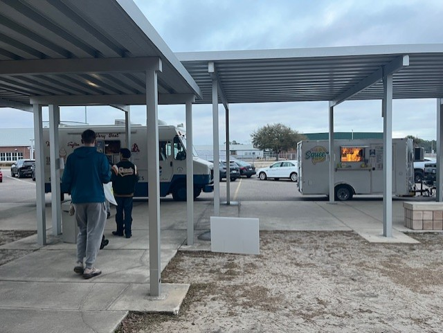 Students walk outside near food trucks providing complimentary treats following the College & Career Fair.