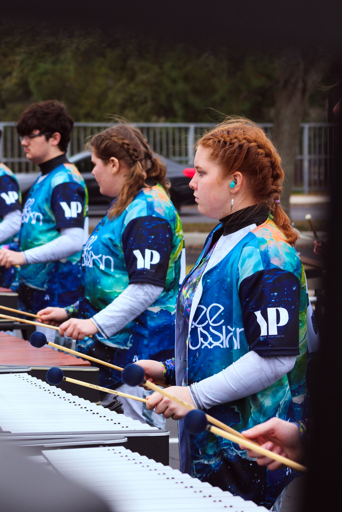 Yulee High School front ensemble students perform together on mallet percussion instruments outdoors before competition.