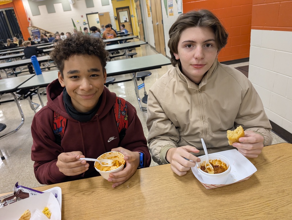 Two students enjoy chili and cornbread in the cafeteria