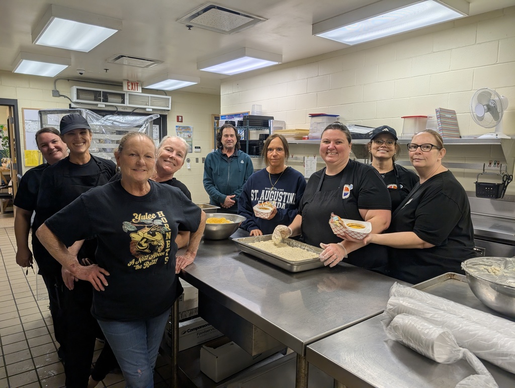 YMS Cafeteria Team poses for a picture in the kitchen, all smiles