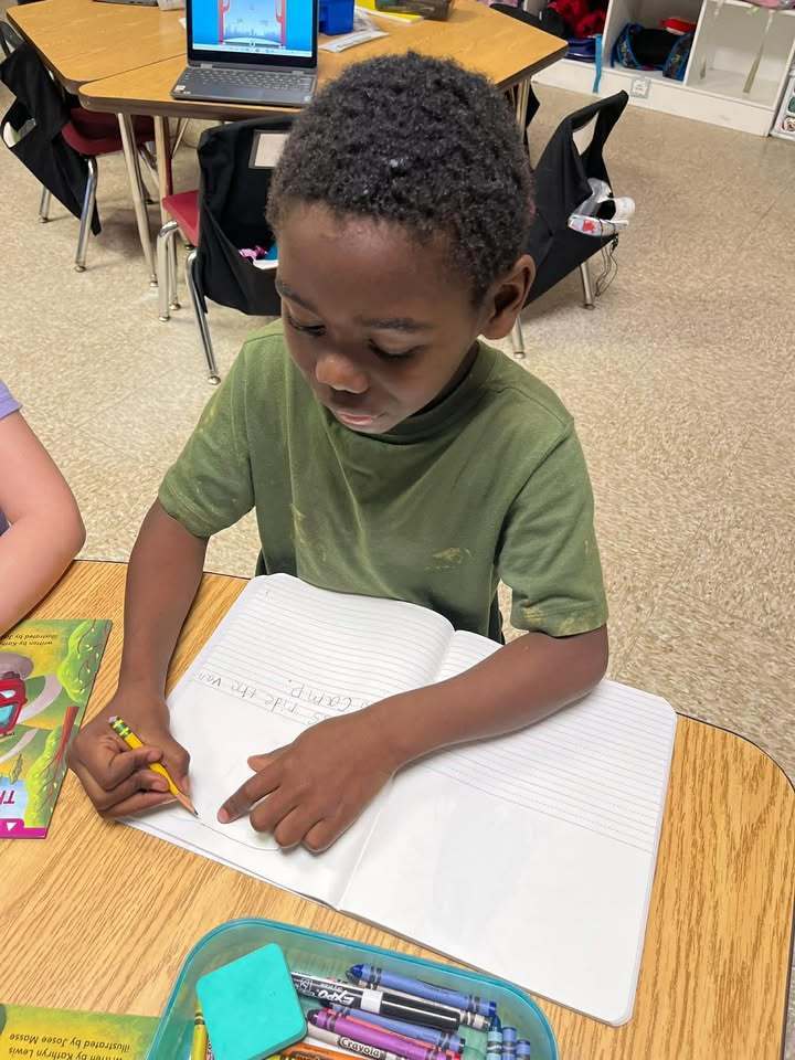 Student writing sentences in his journal. 