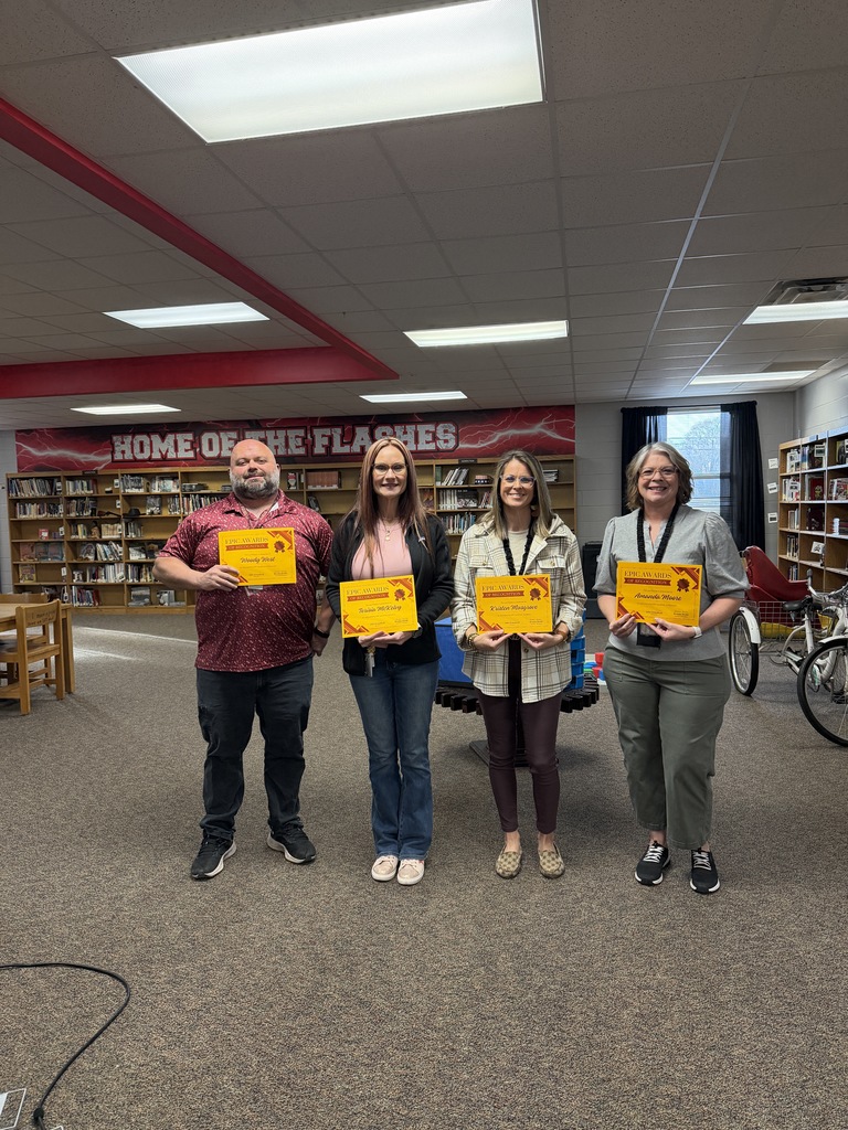 Teachers posing for a picture with their awards.