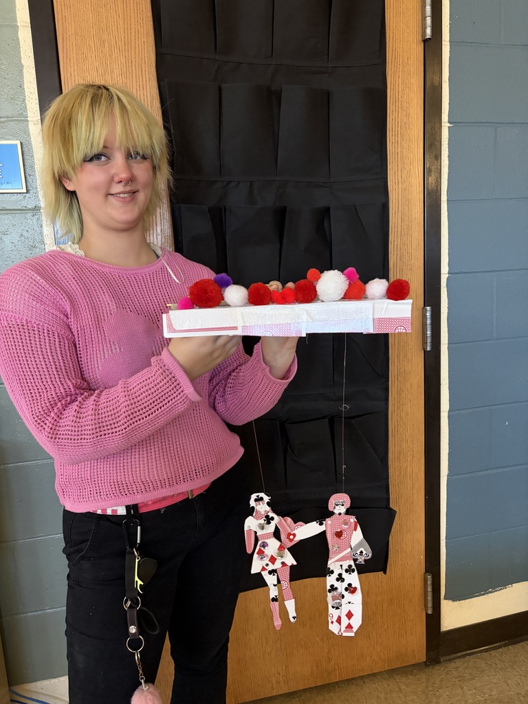 Students displaying artwork.