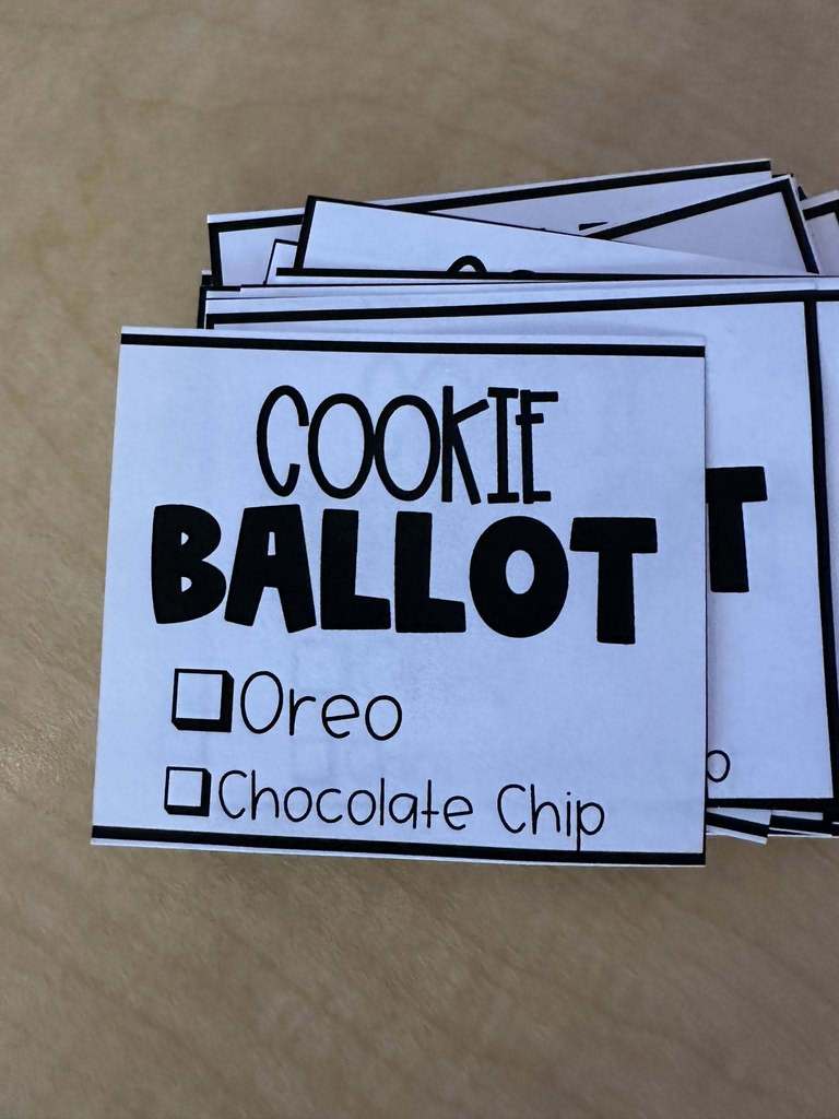 Close-up of printed ballot cards titled “Cookie Ballot” with checkboxes for Oreo and chocolate chip.