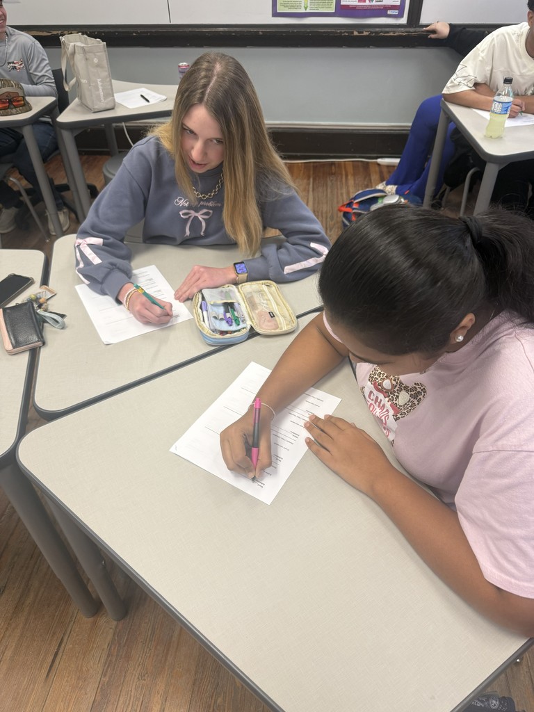 Students sitting at desk writing.