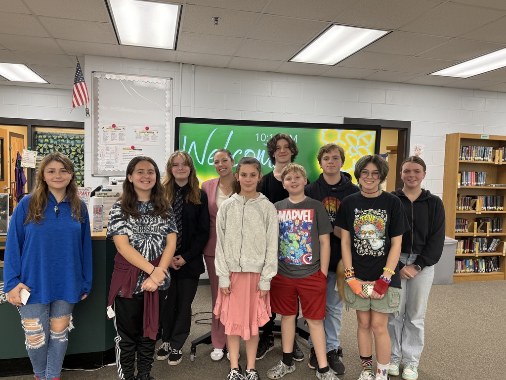 Student participants smiling for the camera with their Principal, Dr. Middleton, after the 4-H speech contest. The picture was taken in the school's library.