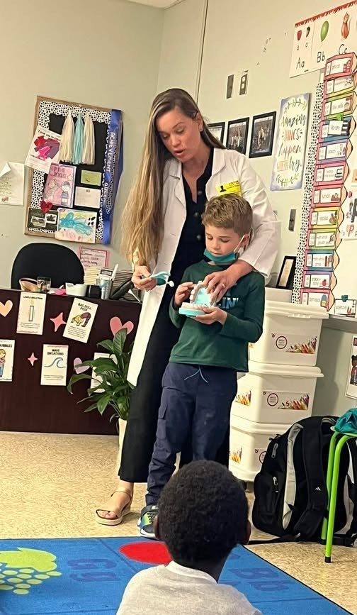 Student demonstrating with Dr. Porter how to have proper dental hygiene with a pretend mouth.