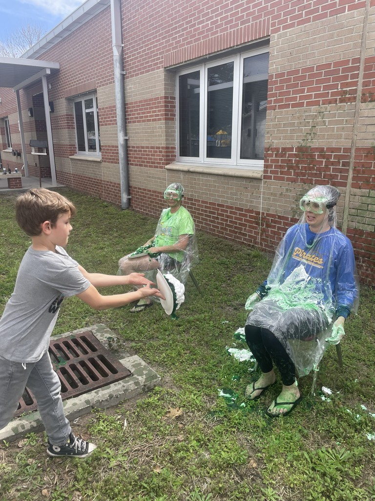 Student throwing shaving cream pie at Dr. Weber.