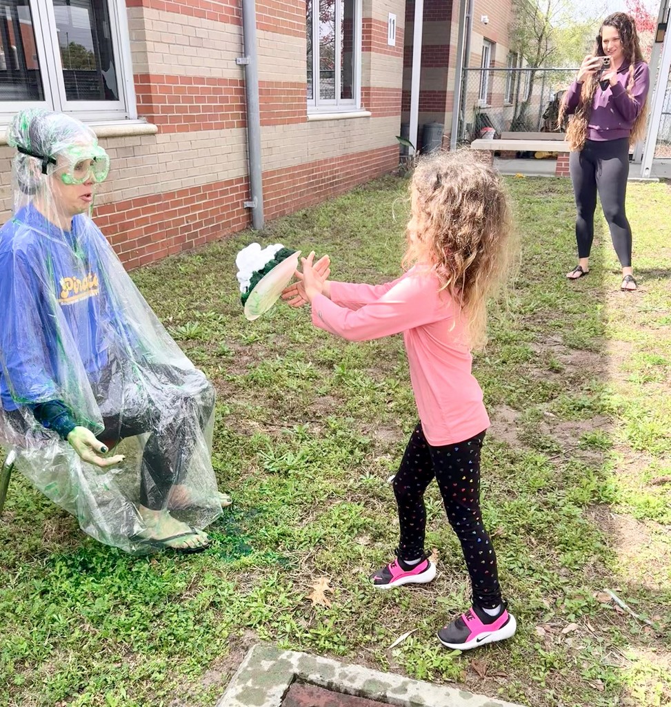Student throwing shaving cream pie at Dr. Weber.