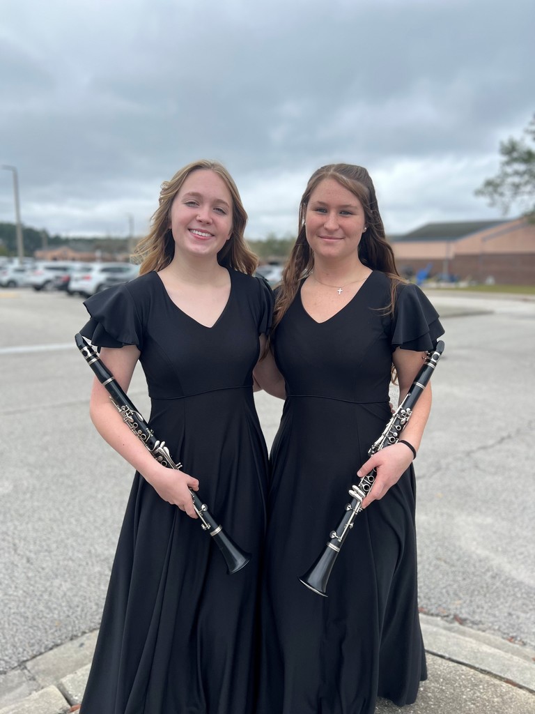 Two students posting with instruments.