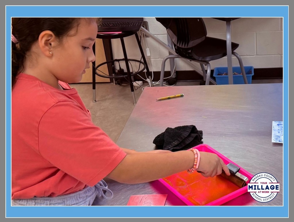 A Wildlight Elementary student participating in a hands-on printmaking activity at a classroom table.