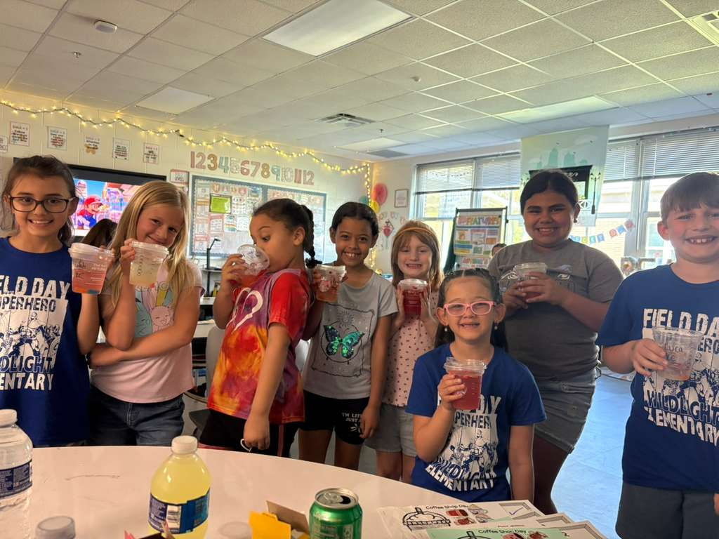 A group of smiling students holding up their refreshing rewards and celebrating the completion of their Poetry Week projects.