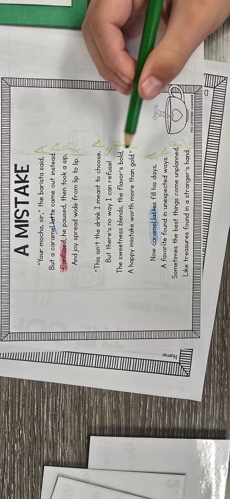 A close-up of a student's hands holding a pencil over their completed poetry worksheet, ready to add the finishing touches.