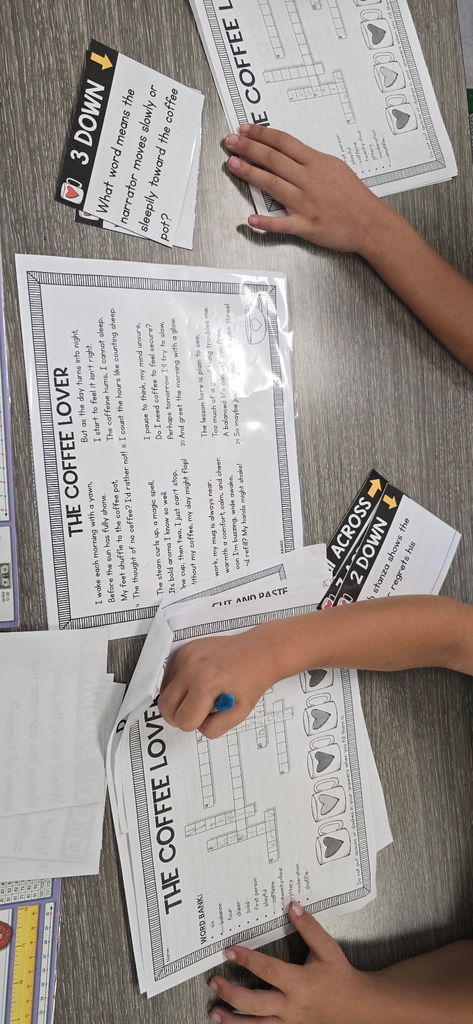 A close-up of a student's hands holding a pencil over their completed poetry worksheet, ready to add the finishing touches.