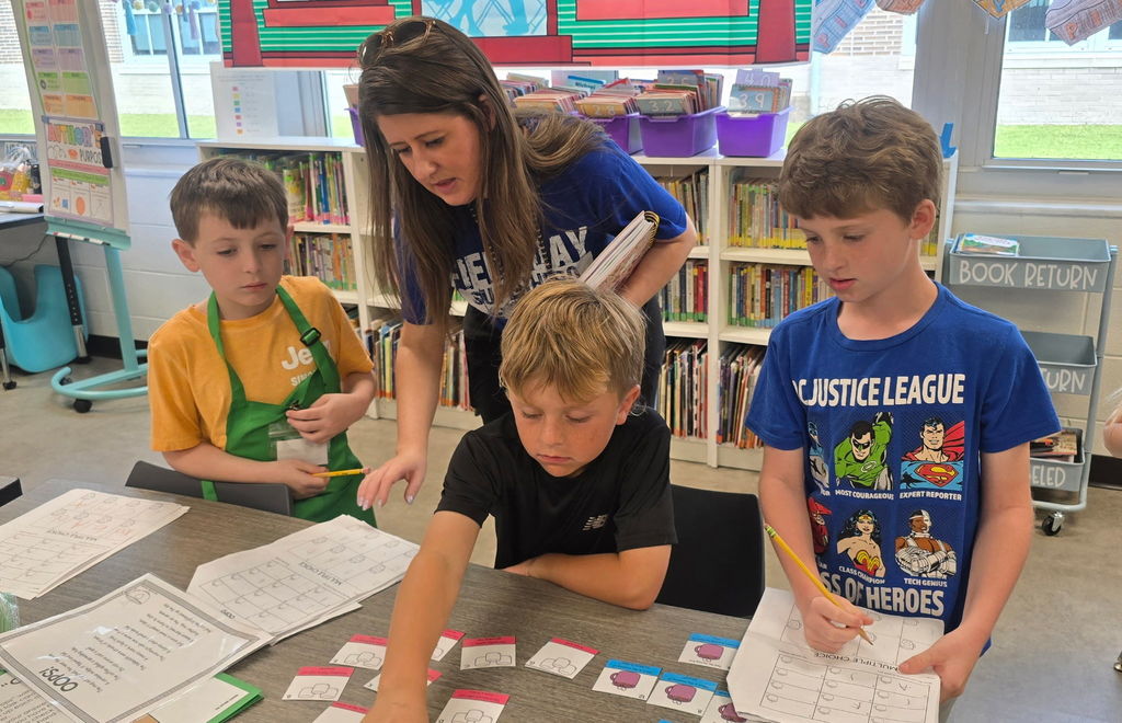 Students working in a classroom transformed for Poetry Week, with Starbucks-themed decorations and instructional materials on the tables.