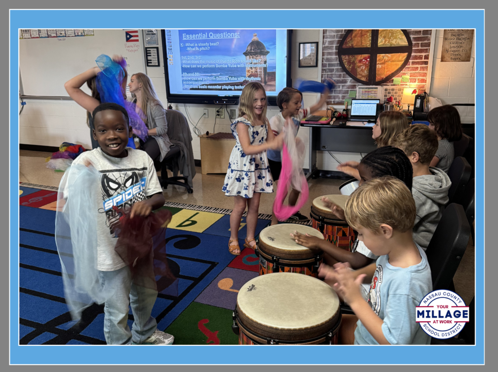 Students at Wildlight Elementary participating in a music lesson with drums and colorful scarves.