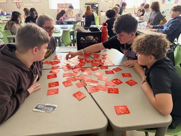Students learn with cards at a group station for Fun Friday