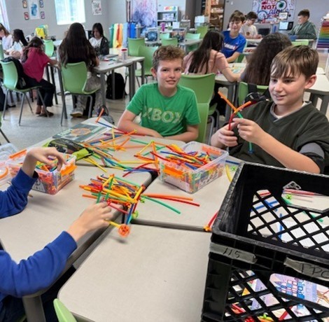 Students learn with multi-colored, bendable wire at their learning station. 