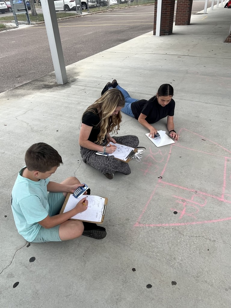Students working math problems on the concrete.