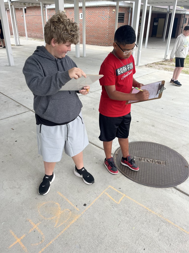 Students working math problems on the concrete.